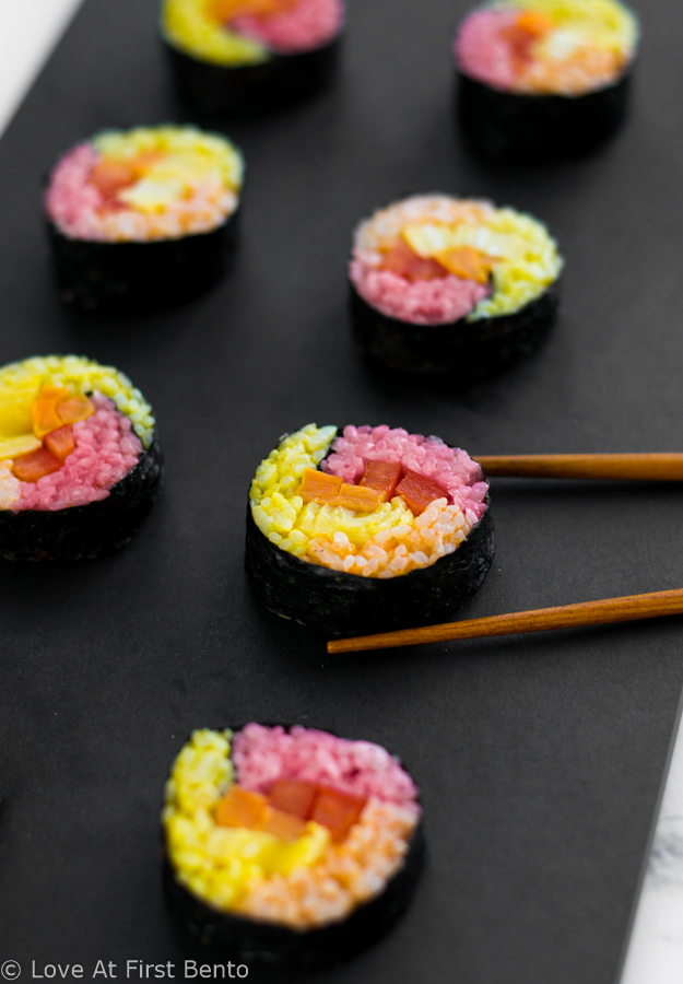 Autumn Colored Sushi - Naturally dyed red, orange, & yellow rice rolled up with your favorite fillings, these sushi rolls are a real showstopper that anyone can master! Step-by-step instructions + video tutorial available at loveatfirstbento.com | fall, bento box, lunch, recipe