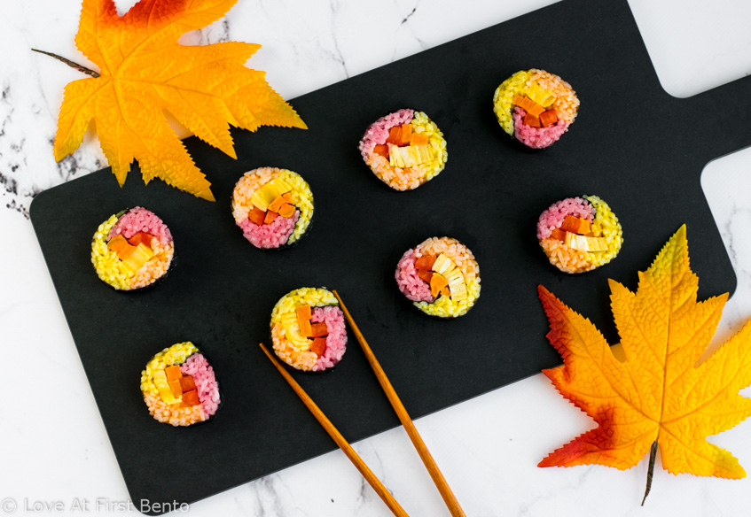 Autumn Colored Sushi - Naturally dyed red, orange, & yellow rice rolled up with your favorite fillings, these sushi rolls are a real showstopper that anyone can master! Step-by-step instructions + video tutorial available at loveatfirstbento.com | fall, bento box, lunch, recipe