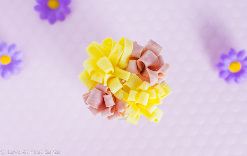 Ham & Egg Flowers - Learn exactly how to make these classic bento box space fillers with the help of a video tutorial. They taste delicious, and can be prepared in mere minutes. No more empty spaces in your bento! | www.loveatfirstbento.com