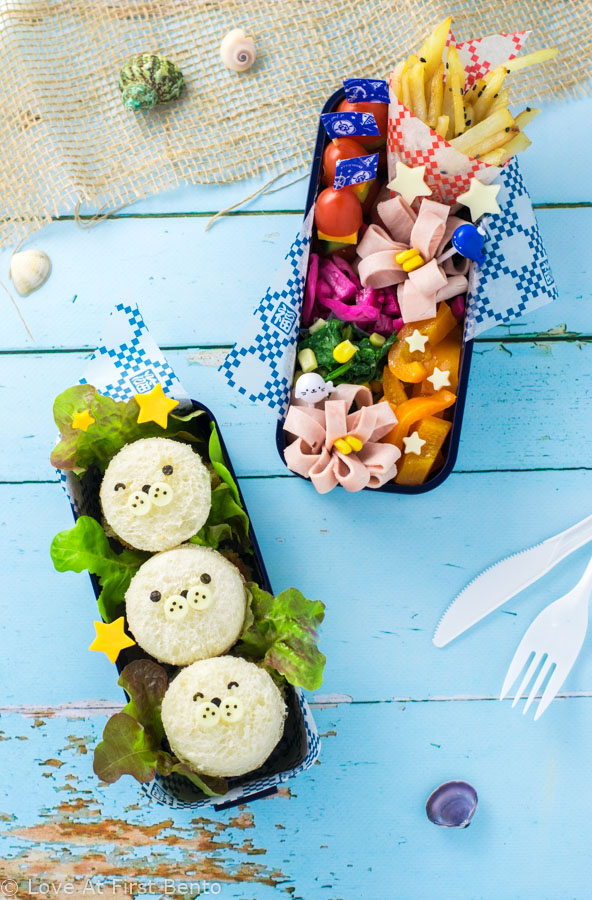 Mini Baby Seal Fish Burgers Bento Box - Learn how easy it is to make these adorable baby seals for lunch! Easy, delicious, and almost too cute to eat, they make the perfect addition to any nautical themed bento box. | loveatfirstbento.com