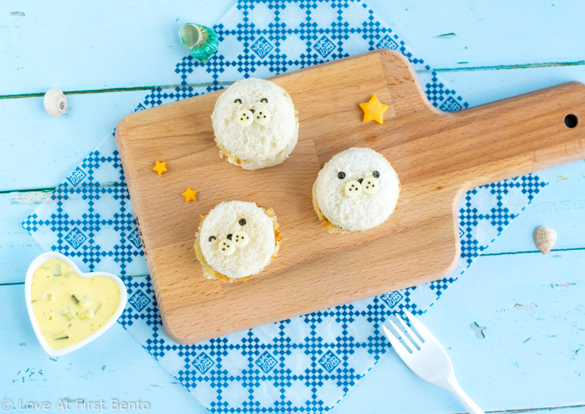 Mini Baby Seal Fish Burgers Bento Box - Learn how easy it is to make these adorable baby seals for lunch! Easy, delicious, and almost too cute to eat, they make the perfect addition to any nautical themed bento box. | loveatfirstbento.com