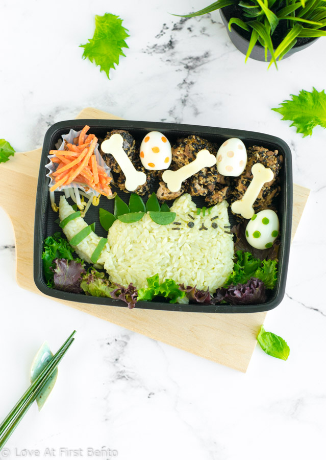Pusheenosaurus Bento Box - Pusheen the Cat goes prehistoric in this dinosaur themed character bento box! Learn the trick that makes shaping the rice easier, + how to naturally dye your rice green, at www.loveatfirstbento.com