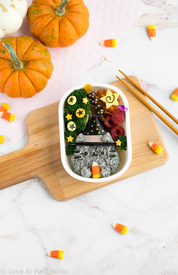 Witch Pusheen Halloween Bento Box - Make a Halloween lunch that's so cute, it's scary, thanks to the always adorable Pusheen the Cat! You won't be able to guess the 2 kitchen "magic tricks" used to make preparing this bento way faster & easier. Get the step-by-step instructions + video tutorial for this bento at: loveatfirstbento.com | charaben, kyaraben, character bento