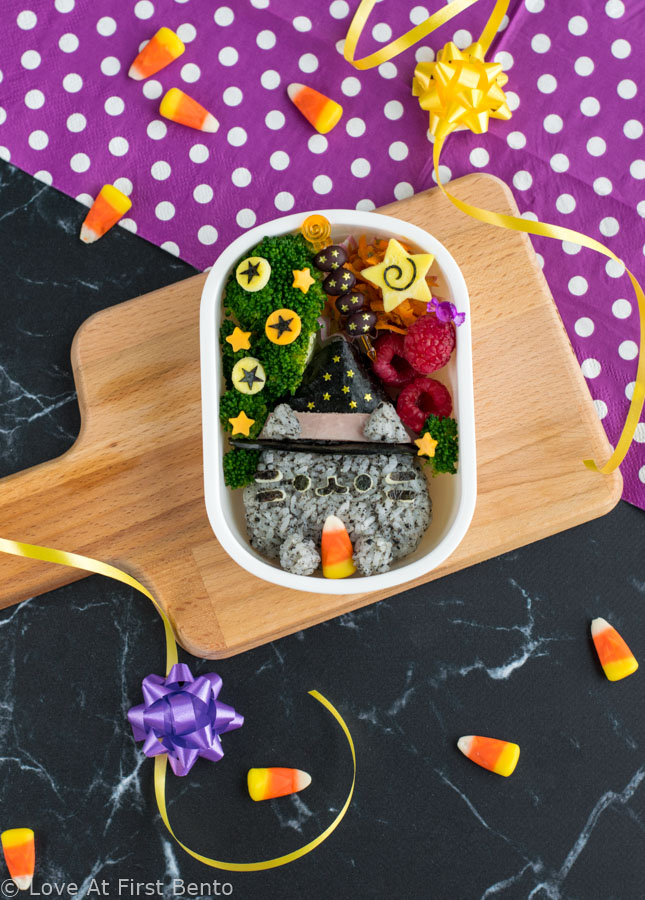 Witch Pusheen Halloween Bento Box - Make a Halloween lunch that's so cute, it's scary, thanks to the always adorable Pusheen the Cat! You won't be able to guess the 2 kitchen "magic tricks" used to make preparing this bento way faster & easier. Get the step-by-step instructions + video tutorial for this bento at: loveatfirstbento.com | charaben, kyaraben, character bento