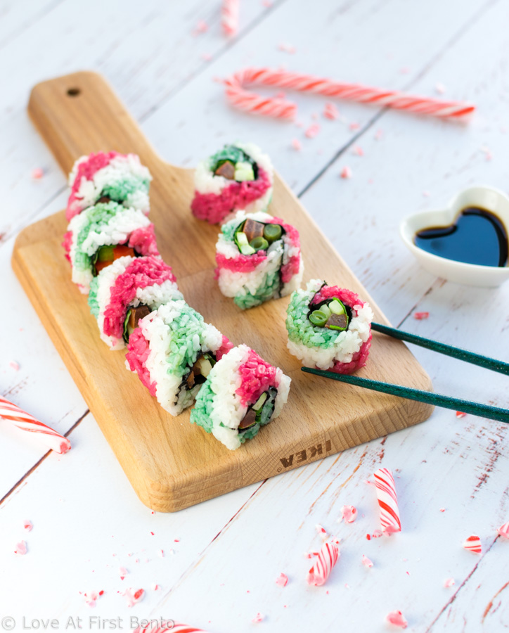Candy Cane Sushi Rolls - These beautiful uramaki (inside-out) rolls are 100% vegan, and get their colorful stripes from all-natural homemade dyes. Step-by-step video tutorial + tips & tricks will have you rolling out these fun & colorful sushi rolls with ease! Perfect for Christmas bento boxes and holiday party appetizers. | loveatfirstbento.com