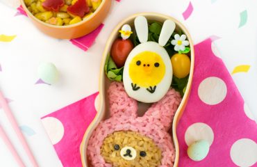Bunny Rilakkuma Easter Bento - Learn how to turn Rilakkuma & Kiiroitori into adorable Easter bunnies, using naturally dyed rice, onigiri molds, and hard-boiled eggs. A guaranteed lunchtime hit for Rilakkuma fans of all ages! Get the recipe at: loveatfirstbento.com {character bento box, kyaraben, rabbit}