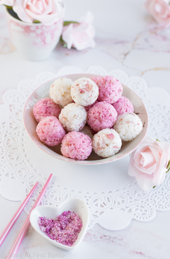 Salted Rose Onigiri - WOW your friends with the unique flavor of pickled rose petals, which take these rice balls to a whole new level of edible elegance! Plus, I reveal a super easy, 2-ingredient rose salt recipe perfect for sprinkling on top. These onigiri are absolutely perfect for a Mother's Day or spring bento box - a guaranteed crowd-pleaser! Get the recipe at loveatfirstbento.com
