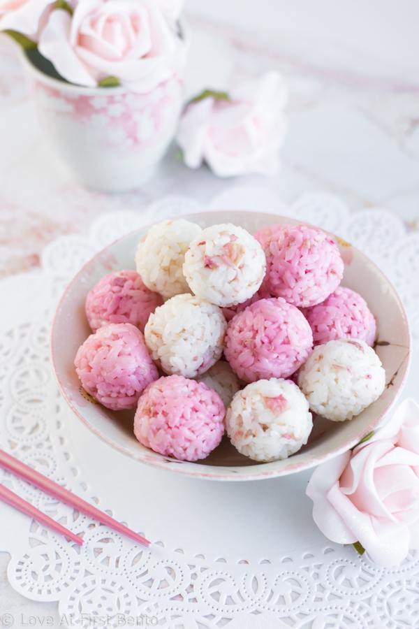 Salted Rose Onigiri - WOW your friends with the unique flavor of pickled rose petals, which take these rice balls to a whole new level of edible elegance! Plus, I reveal a super easy, 2-ingredient rose salt recipe perfect for sprinkling on top. These onigiri are absolutely perfect for a Mother's Day or spring bento box - a guaranteed crowd-pleaser! Get the recipe at loveatfirstbento.com